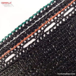 Primer plano de una malla sombra negra OBAMALLA® con un tejido de plástico que forma un patrón de líneas entrecruzadas. La malla tiene bordes reforzados con hilos verdes y una línea central de color naranja, destacando su diseño resistente. El logotipo de OBAMALLA® está visible en la esquina superior izquierda y el sitio web hortomallas.com en la esquina inferior derecha.
