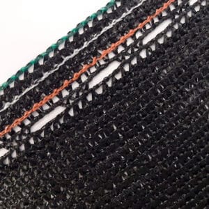 Primer plano de una malla sombra negra OBAMALLA® con un tejido de plástico que forma un patrón de líneas entrecruzadas. La malla presenta bordes reforzados con hilos verdes y una línea central de color naranja, destacando su diseño resistente y funcional. El logotipo de OBAMALLA® está visible en la esquina superior izquierda y el sitio web hortomallas.com en la esquina inferior derecha.